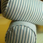 Feather bolsters with piped covers in blue and white ticking